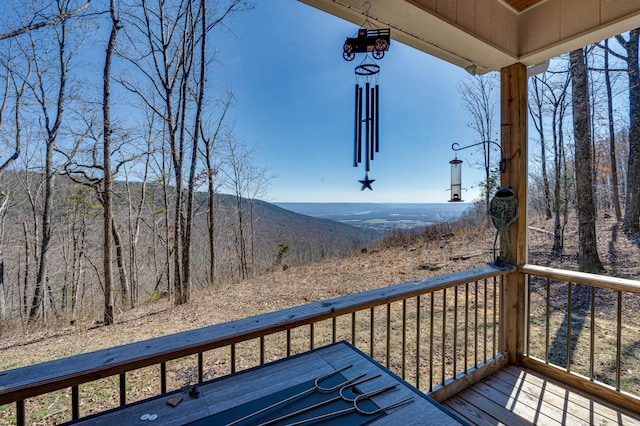 wooden terrace featuring a mountain view and a forest view