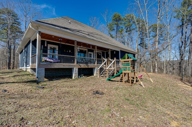 rear view of property featuring a shingled roof and a porch