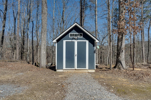 view of shed with a wooded view