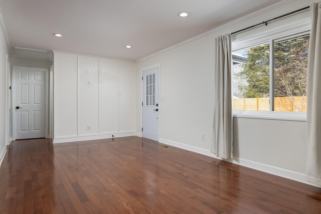 spare room featuring crown molding, recessed lighting, dark wood-type flooring, attic access, and baseboards