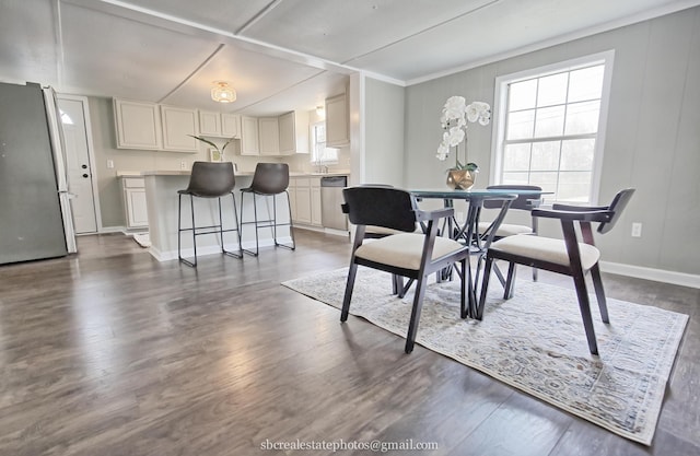 dining room featuring dark wood-type flooring and a healthy amount of sunlight
