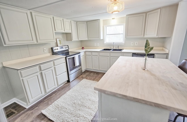 kitchen featuring sink, dark hardwood / wood-style floors, a kitchen island with sink, and stainless steel appliances