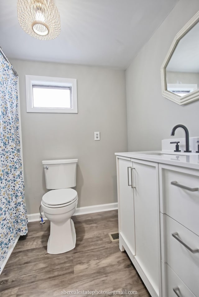 bathroom with hardwood / wood-style flooring, vanity, and toilet