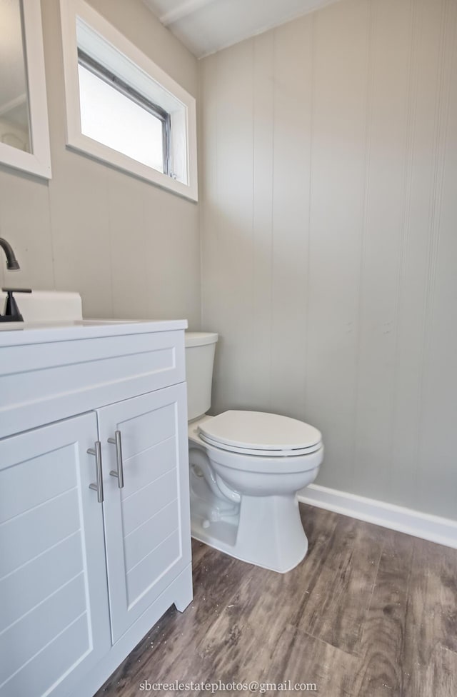bathroom with hardwood / wood-style flooring, vanity, and toilet