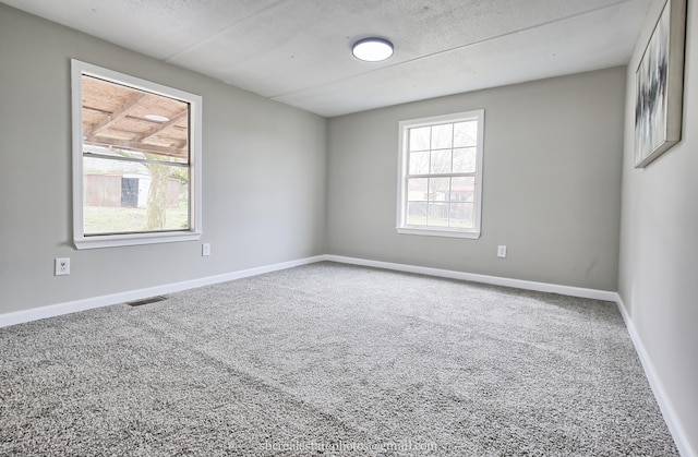 carpeted spare room featuring a textured ceiling