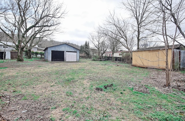 view of yard featuring a garage and an outdoor structure