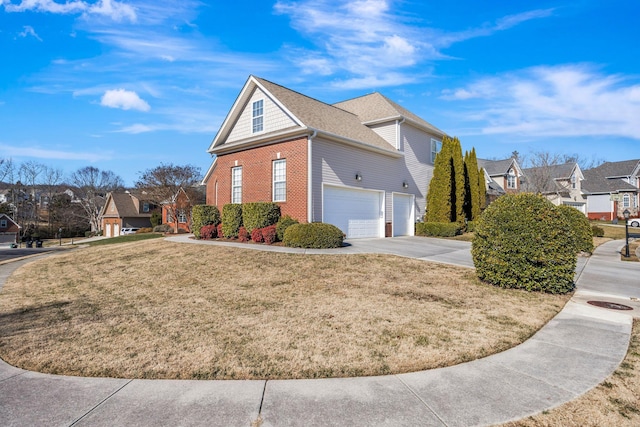 view of home's exterior featuring a yard, concrete driveway, brick siding, and a residential view