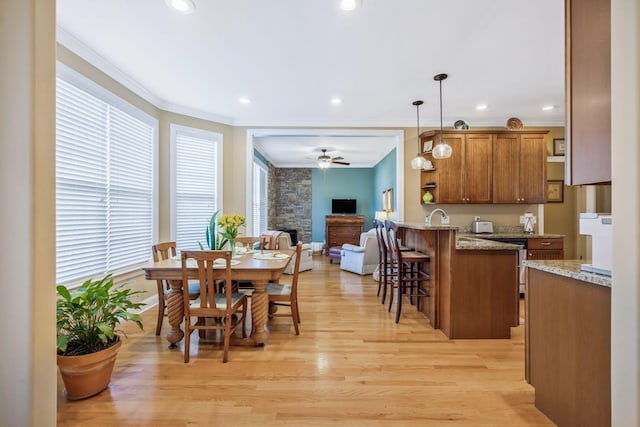 dining area with light wood-style floors, ornamental molding, a ceiling fan, and recessed lighting