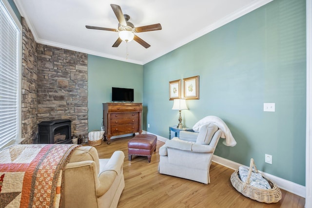 living area with ceiling fan, baseboards, crown molding, and wood finished floors