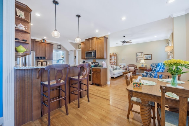 kitchen with light wood-style flooring, a peninsula, stainless steel appliances, crown molding, and open shelves