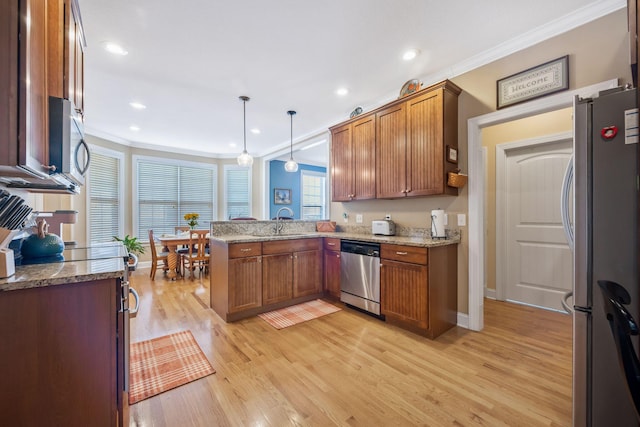 kitchen featuring stainless steel appliances, brown cabinetry, a peninsula, and a sink