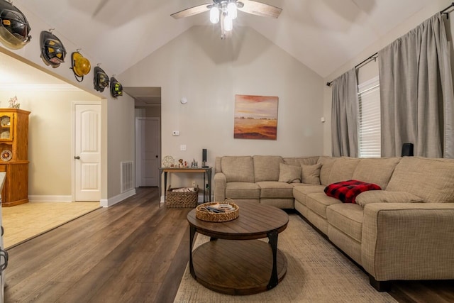 living room featuring ceiling fan, dark wood-type flooring, and vaulted ceiling