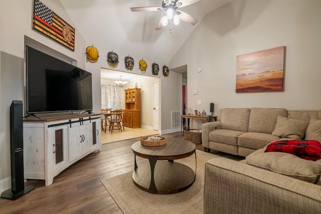 living room featuring ceiling fan with notable chandelier, high vaulted ceiling, and wood-type flooring