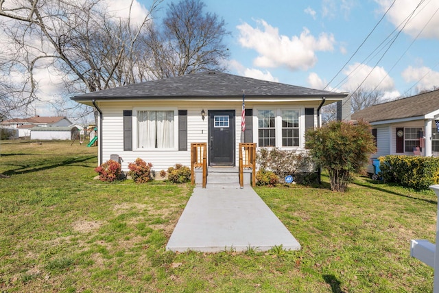 bungalow with a front yard and roof with shingles