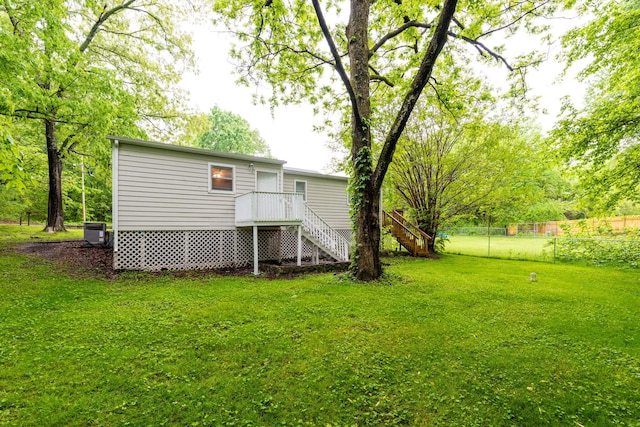 back of property featuring cooling unit and a yard