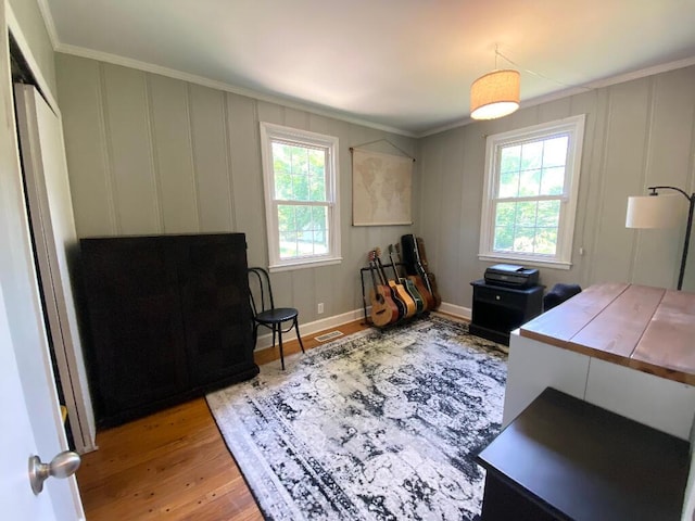 office area with ornamental molding and light hardwood / wood-style floors