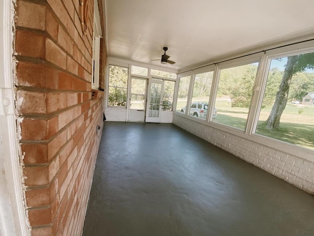 unfurnished sunroom featuring ceiling fan