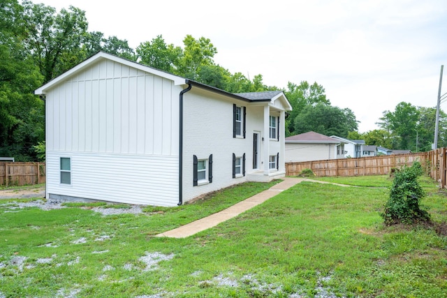 rear view of property with a yard