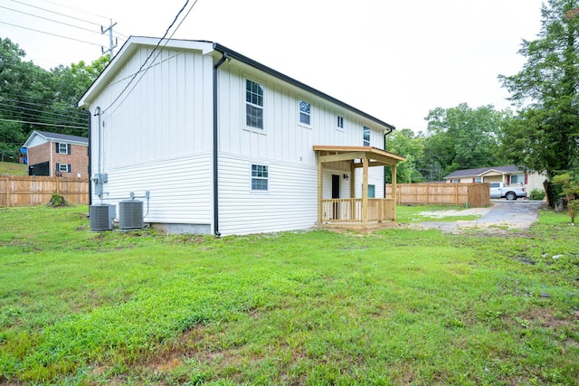 rear view of house with a yard and central AC