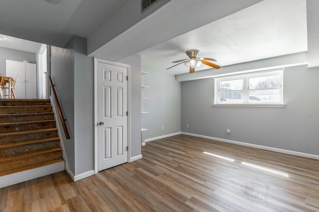 stairs featuring a ceiling fan, visible vents, baseboards, and wood finished floors