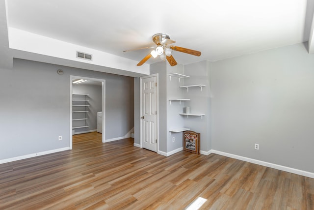 interior space with a closet, wood finished floors, visible vents, and baseboards