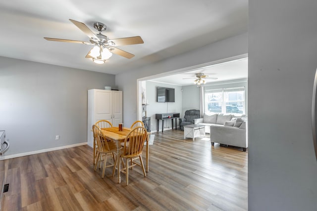 dining space featuring ceiling fan, baseboards, and wood finished floors