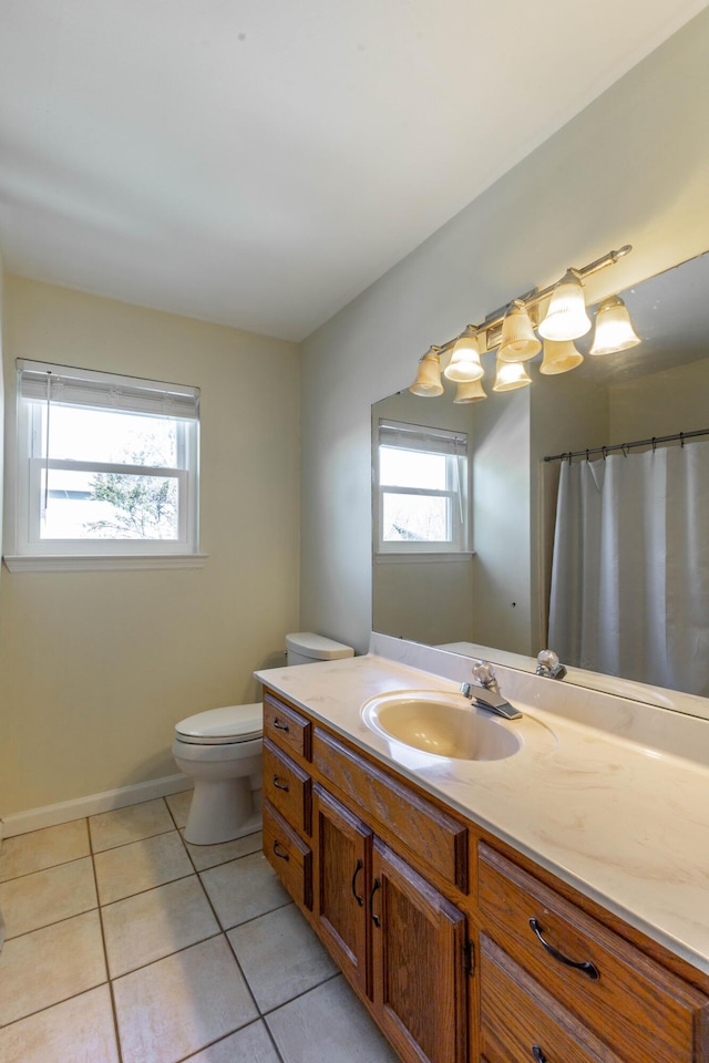 bathroom featuring baseboards, vanity, toilet, and tile patterned floors