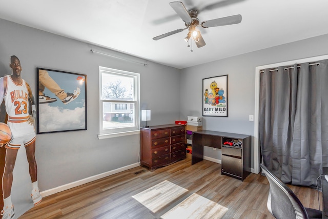 office with light wood finished floors, a ceiling fan, and baseboards