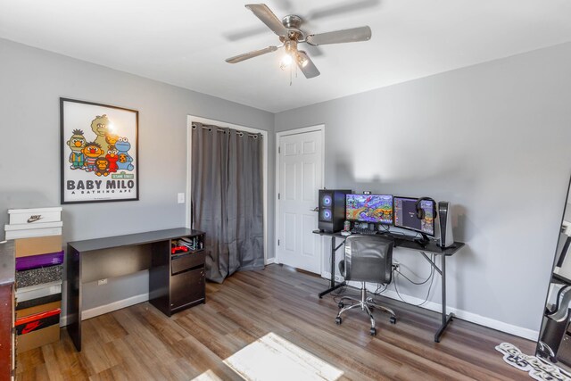 office space featuring wood finished floors, a ceiling fan, and baseboards