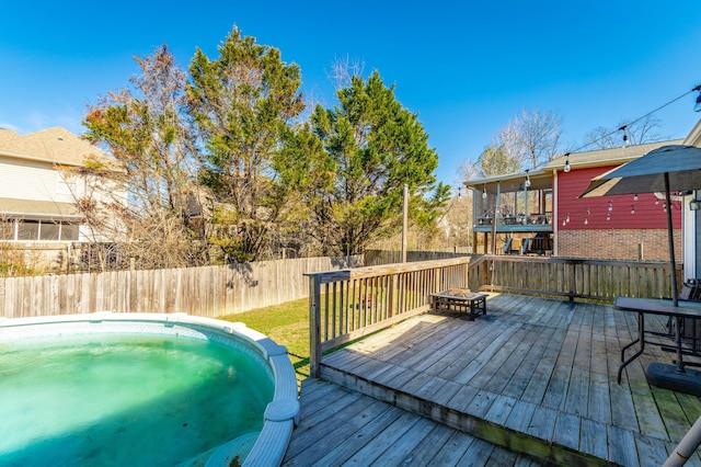 wooden terrace with a fenced backyard