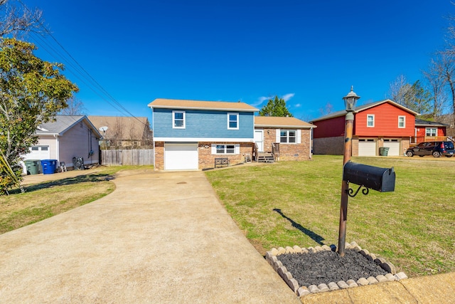 split level home with an attached garage, brick siding, fence, driveway, and a front yard