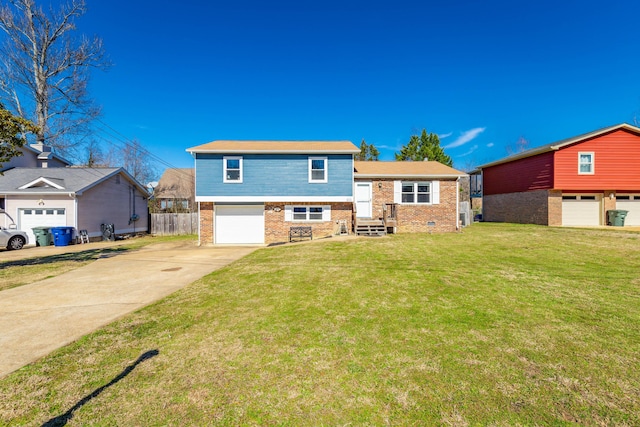 split level home with driveway, brick siding, crawl space, fence, and a front yard