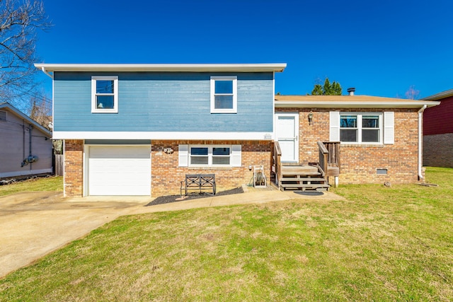 split level home with a garage, driveway, a front yard, and brick siding