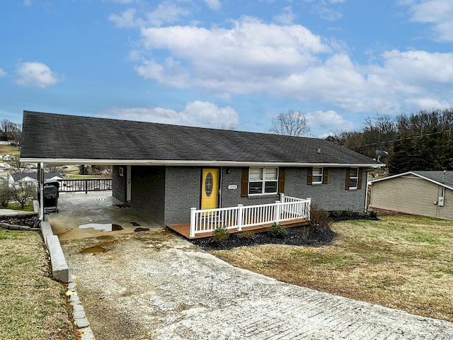 ranch-style house featuring a carport, a porch, and a front yard