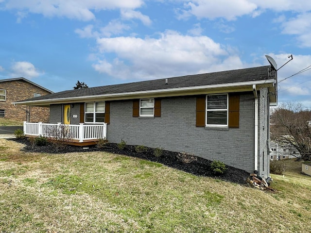 ranch-style home with covered porch and a front lawn