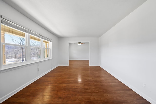 spare room featuring dark wood finished floors, baseboards, and ceiling fan