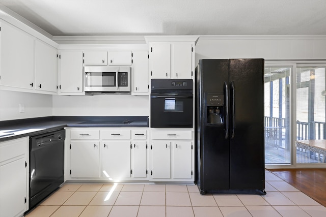 kitchen with black appliances, light tile patterned flooring, dark countertops, and white cabinetry
