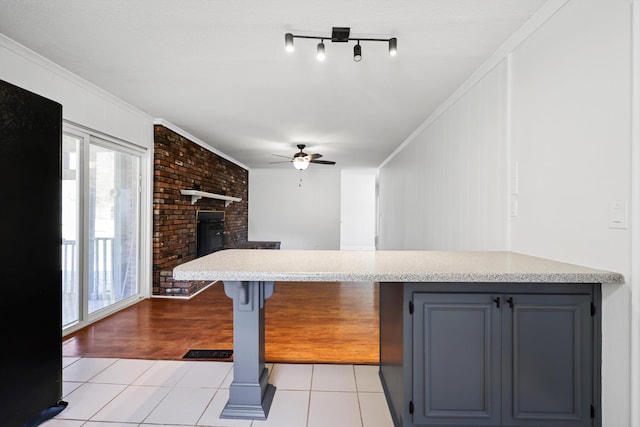 kitchen featuring light tile patterned floors, light countertops, ceiling fan, and crown molding