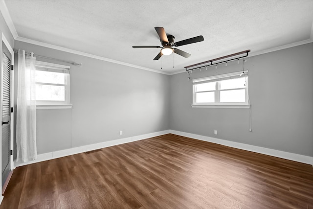 spare room featuring dark wood finished floors, visible vents, and crown molding