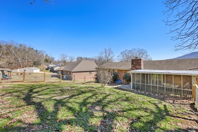 view of yard featuring a sunroom, a gate, and fence