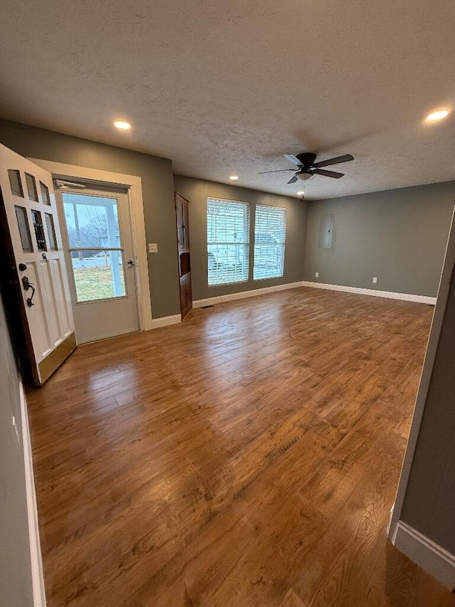 interior space featuring ceiling fan, dark hardwood / wood-style floors, a wealth of natural light, and a textured ceiling