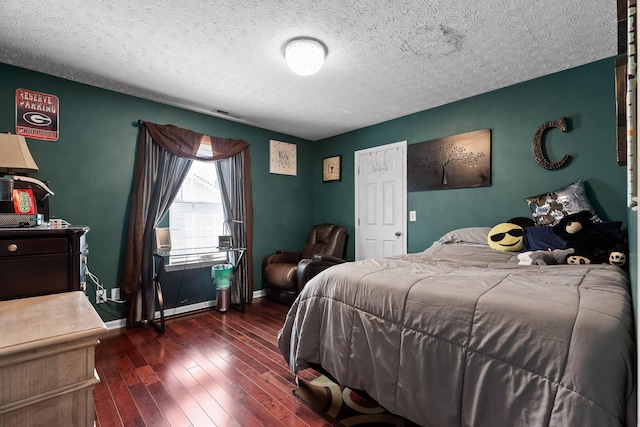 bedroom featuring a textured ceiling and dark hardwood / wood-style flooring