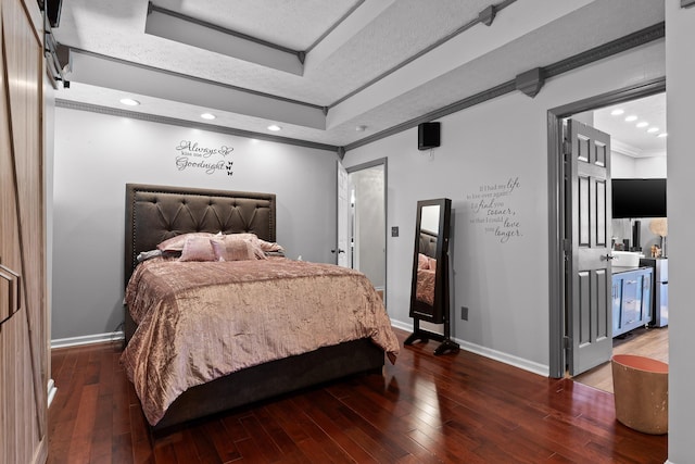 bedroom with dark hardwood / wood-style flooring, ornamental molding, a raised ceiling, and a textured ceiling