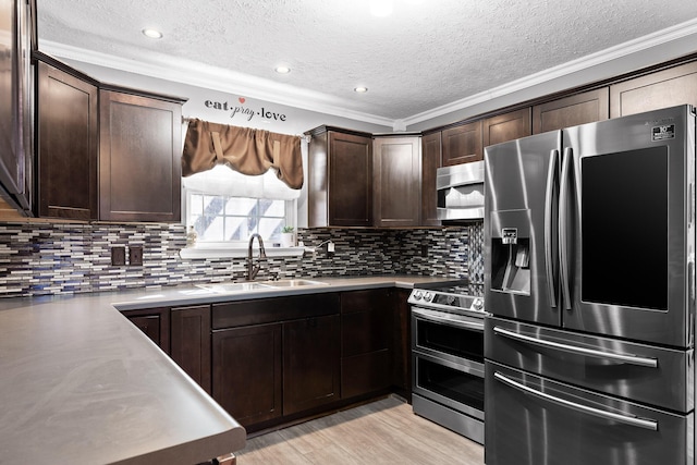 kitchen with appliances with stainless steel finishes, sink, dark brown cabinets, and tasteful backsplash