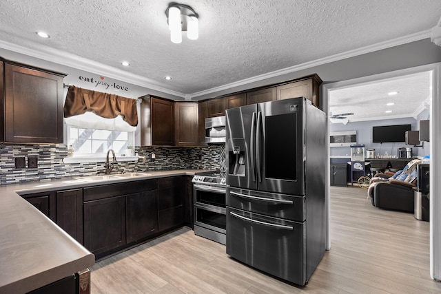 kitchen featuring sink, ornamental molding, dark brown cabinets, and stainless steel appliances