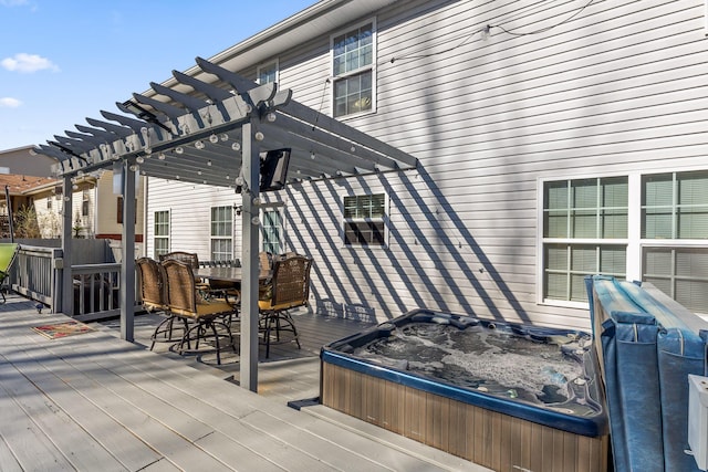 deck featuring a hot tub and a pergola