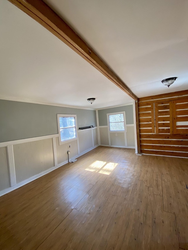 unfurnished living room with a wealth of natural light, hardwood / wood-style floors, and crown molding