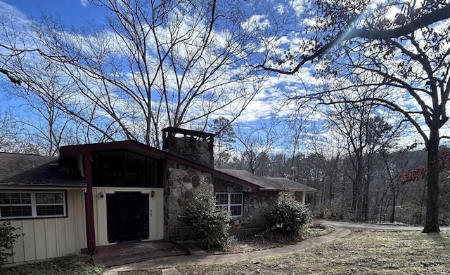 view of front of property with a chimney and stone siding