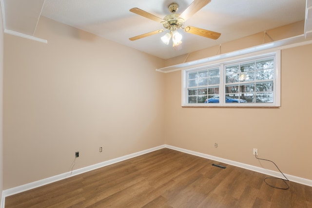 unfurnished room featuring baseboards, visible vents, a ceiling fan, and wood finished floors