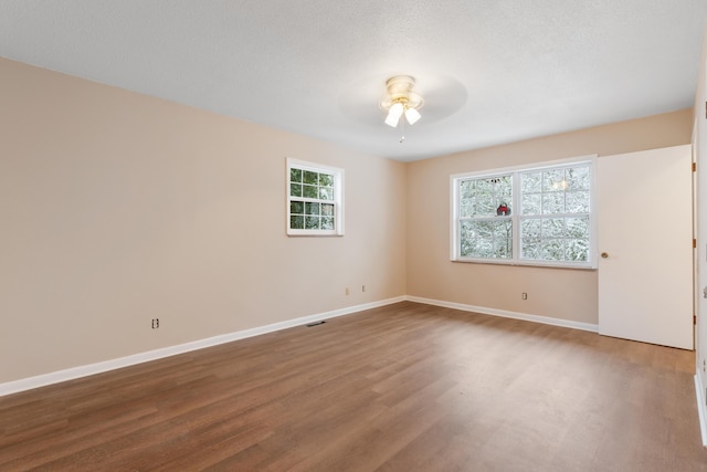 spare room featuring ceiling fan, wood finished floors, and baseboards